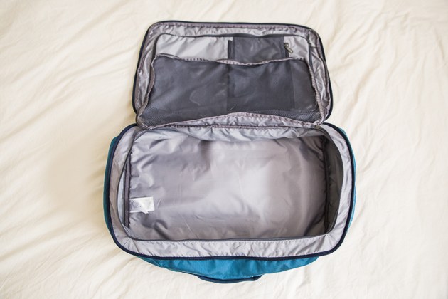 travel bags the patagonia mlc laying on white sheets, zipped wide open and completely  empty. its dlwpzeh