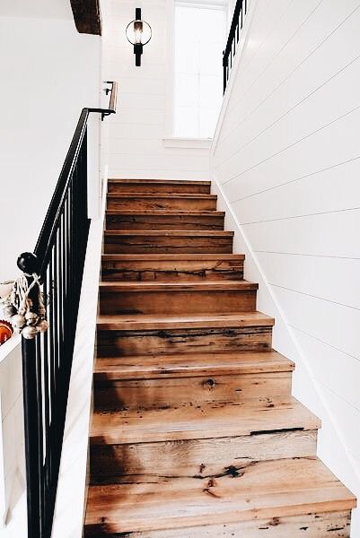 Gorgeous natural wood stairs, black hand rail, white shiplap .
