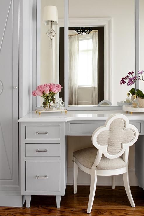 A Suzanne Kasler Alexandra Chair sits at a gray built-in makeup .